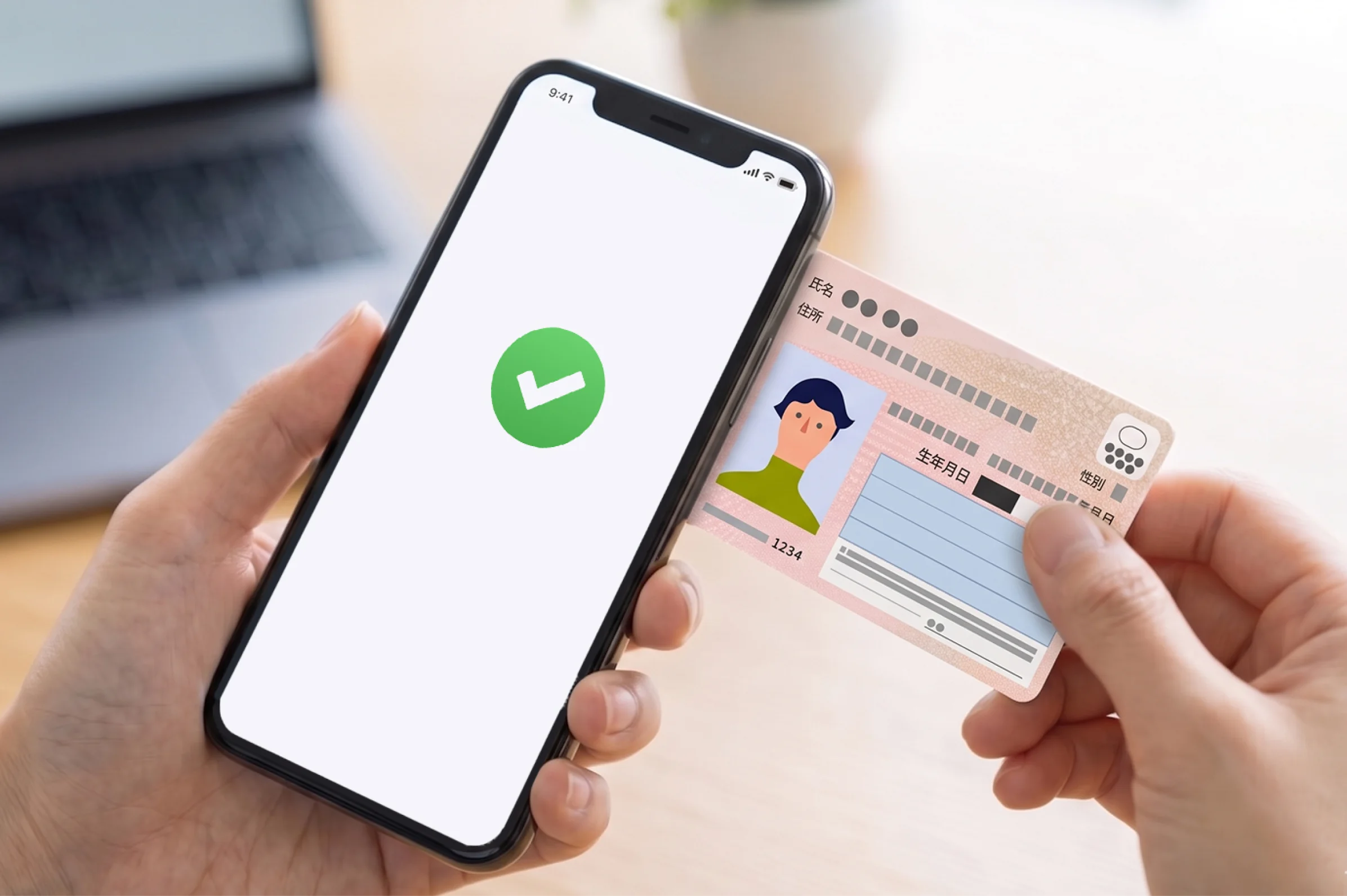 マイナンバーカードと本人確認中のスマートフォン
